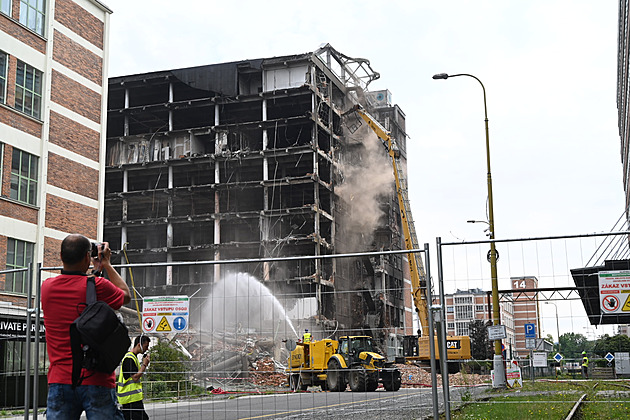Obří nůžky stříhají torzo vyhořelé budovy ve Zlíně, demolici pozorují desítky lidí
